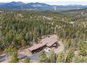 Expansive aerial view of a luxury home surrounded by dense forest and mountain views at 5976 Stone Creek Dr, Evergreen, CO 80439