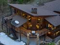 Aerial view of home with tiered balconies, outdoor seating, stone accents, and a chimney at 5976 Stone Creek Dr, Evergreen, CO 80439