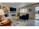 Bright living room with a modern fireplace, large-screen TV, and an inviting front entry at 6020 Quail St, Arvada, CO 80004