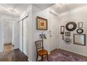 Hallway with wood floors, white walls, coat closet, and decorative mirrors and pictures at 7250 Eastmoor Dr # 203, Denver, CO 80237