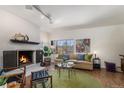 Bright living room with a fireplace, large window, and comfortable seating at 7250 Eastmoor Dr # 203, Denver, CO 80237