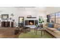 Cozy living room with a brick fireplace, wood floors, modern decor, and large window at 7250 Eastmoor Dr # 203, Denver, CO 80237