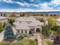 Luxury home with fall foliage, mountain views, and stone accents at 774 Chamberlain Way, Highlands Ranch, CO 80126