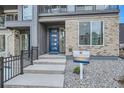 Front entrance of townhome with blue door and stone walkway at 1714 Peak Loop, Broomfield, CO 80023