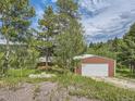 View of a garage with a white door next to a house at 12348 Quartz Spur, Conifer, CO 80433