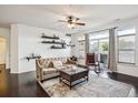 Comfortable living room is bright and airy, with dark hardwood floors, a ceiling fan, and access to outdoor patio at 14221 E 1St Dr # 208, Aurora, CO 80011