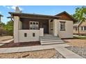 Charming bungalow with a painted brick exterior, covered porch, and well-maintained landscaping at 1455 Hudson St, Denver, CO 80220