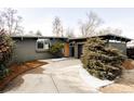 Charming single-story home featuring a concrete driveway, modern architectural details, and mature landscaping at 1459 S Filbert Way, Denver, CO 80222