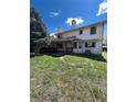 Backyard featuring a partially covered deck, mature tree, and green lawn with shade at 15983 E Loyola Dr, Aurora, CO 80013
