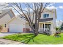 Inviting two-story home featuring a covered porch, mature tree, and attached two-car garage at 19058 E Hickock Dr, Parker, CO 80134