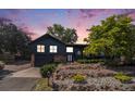 Stylish two-story home with black siding, stone accents, and beautifully landscaped front yard at 14890 W 58Th Pl, Golden, CO 80403