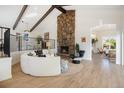 Inviting living room with vaulted ceilings, wooden beams, a stone fireplace, and modern decor at 14890 W 58Th Pl, Golden, CO 80403