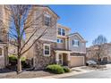 Charming two-story home features a stone facade, attached garage, and mature tree at 10120 Fenwick St, Parker, CO 80134
