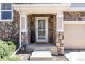 The front porch features stone accents and provides a charming entrance to the house at 10120 Fenwick St, Parker, CO 80134