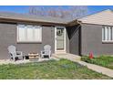 Inviting front entrance of home with gray brick, blooming flowers, and charming seating area at 373 S Locust St, Denver, CO 80224