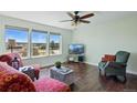 Bright living room with hardwood floors, cozy seating, and expansive windows with scenic views at 2781 Savage Rd, Elizabeth, CO 80107