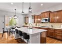 Beautiful kitchen features a large island with seating, stainless steel appliances and modern pendant lighting at 14134 Glenayre Cir, Parker, CO 80134
