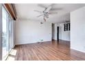 Bright living room featuring wood floors, a ceiling fan, and sliding glass doors to a deck at 3351 S Field St # 164, Lakewood, CO 80227