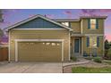 Charming home featuring a two-car garage, well-kept lawn, and a welcoming entrance with blue accents at 828 Lehigh Cir, Erie, CO 80516