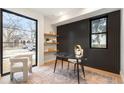 Stylish home office with hardwood floors, black accent wall, floating shelves, and marble desk at 3049 S Cherokee St, Englewood, CO 80110