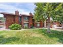 Exterior shot of the property featuring a well-manicured lawn and mature shade trees at 1255 S Dillon Way, Aurora, CO 80012