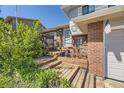 Cozy front entrance featuring brick accents, wooden steps, and charming decor at 4845 S Taft St, Morrison, CO 80465