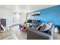 Bright living room with blue accent wall, gray sofa, and patterned rug creating a cozy and inviting space at 3660 S Ouray Cir, Aurora, CO 80013
