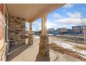 Covered porch with stone pillars offering a relaxing view of the neighborhood at 464 N Jamestown Way, Aurora, CO 80018