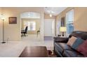 Spacious living room with a leather sofa, hardwood floors and access to home office at 464 N Jamestown Way, Aurora, CO 80018