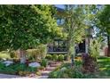 Beautifully landscaped front yard with mature trees and charming curb appeal at 210 N Garfield St, Denver, CO 80206