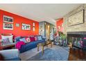 Bright living room boasting vibrant red walls, a stone fireplace, and comfortable seating at 2991 W 81St Ave # G, Westminster, CO 80031