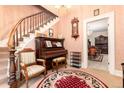 Elegant entryway with vintage piano, curved staircase and ornate furnishings at 200 Rose St, Georgetown, CO 80444