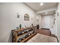 Welcoming entryway featuring a rustic wood console table with decorative accents, complemented by warm-toned flooring and lighting at 42363 Glen Abbey Dr, Elizabeth, CO 80107