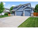 Charming two-story home featuring a covered front porch and a three car attached garage at 17395 E Dewberry Dr, Parker, CO 80134