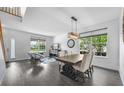 Bright living room features dark wood floors, large windows, and a dining area at 17395 E Dewberry Dr, Parker, CO 80134