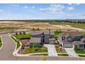 Elevated view of a modern home boasting stone accents, a three-car garage, and spacious surroundings at 8299 S Kellerman, Aurora, CO 80016