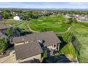 Expansive aerial view of a home overlooking a lush golf course with scenic mountain views at 1743 Homestead Dr, Fort Lupton, CO 80621