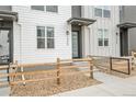 Inviting townhome with wood fence, manicured front yard, and covered entryway, showcasing modern curb appeal at 3458 W 63Rd Ave, Denver, CO 80221