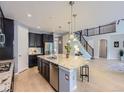 Modern kitchen featuring a large island and open floor plan with hardwood floors and stairs at 10045 Copenhagen St, Parker, CO 80134