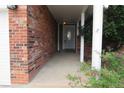 Covered front entrance with brick siding, painted white door and trim, and a concrete porch at 19025 E Bethany Pl, Aurora, CO 80013