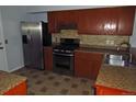 Kitchen with stainless steel appliances, wood cabinets, and a tile backsplash at 19025 E Bethany Pl, Aurora, CO 80013