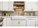 Kitchen features stainless appliances, farmhouse sink, subway tile backsplash and open shelving at 6513 Pinewood Dr, Parker, CO 80134