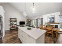 Open-concept kitchen with an island, stainless appliances, pendant lighting, adjacent to the dining and living room at 6513 Pinewood Dr, Parker, CO 80134