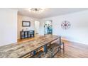 Spacious dining room with wood floors, large table, and eye-catching light fixture at 3241 Sheridan Blvd, Wheat Ridge, CO 80212