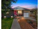 Charming brick home with a pink front door and walkway lights at dusk at 3241 Sheridan Blvd, Wheat Ridge, CO 80212
