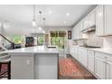 Well-lit kitchen featuring white cabinets, quartz countertops, stainless steel appliances, and hardwood flooring at 1920 Pioneer Cir, Lafayette, CO 80026