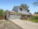 Spacious driveway leading to a well-maintained two-car garage with charming two-story home at 14665 E Stanford Pl, Aurora, CO 80015