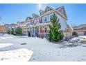 Two-story home with red front door, snow-covered yard, and evergreen trees at 14653 E Crestridge Dr, Centennial, CO 80015