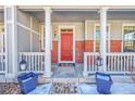 Inviting front porch with red door and white columns at 14653 E Crestridge Dr, Centennial, CO 80015