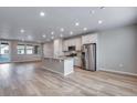 Open-concept kitchen featuring a center island with stone countertops, stainless steel appliances, and abundant natural light at 16744 W 93Rd Pl, Arvada, CO 80007